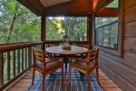 Outside dining on screened in deck with seating for 4